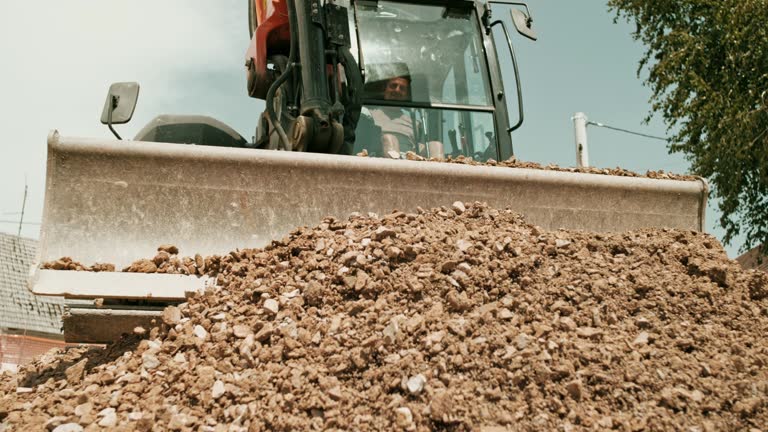 SLO MO LD Excavator pushing crushed rock forward at the construction site