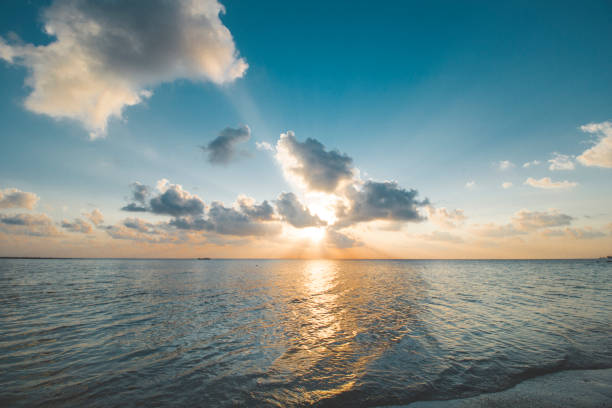 istock Sunset, Cloudy Orange Sky, Calm Wave and Beautiful Tropical Beach 1067438194