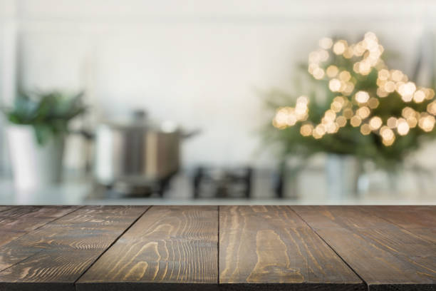 istock Empty wooden tabletop for display products and blurred kitchen with Christmas tree as background. 1067438432