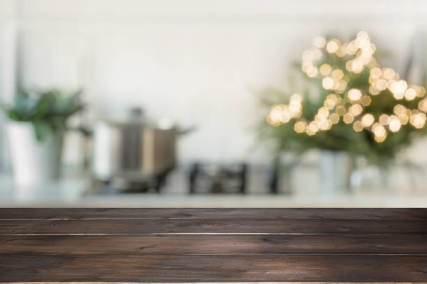 Empty wooden tabletop for display products and blurred kitchen with Christmas tree as background.