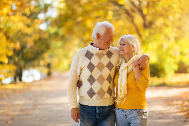 istock Elderly couple together in autumn park 1067443200