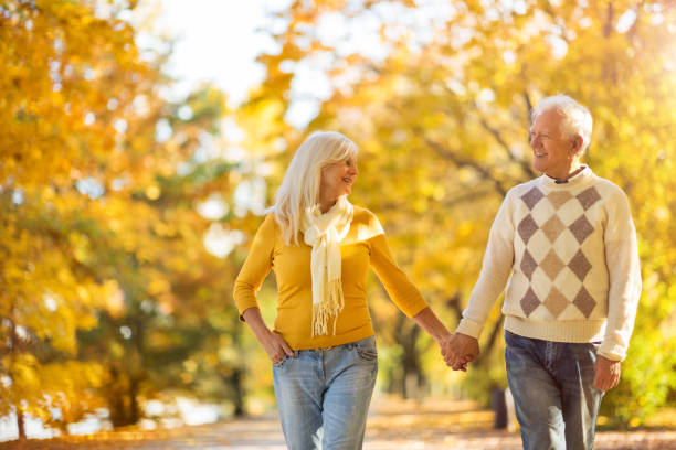 istock Elderly couple together in autumn park 1067443662