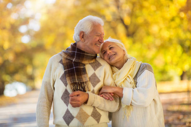 istock Elderly couple together in autumn park 1067443722