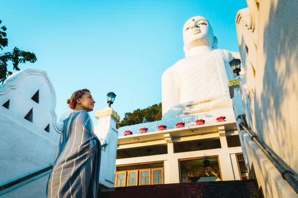 istock Young woman walks up temple steps 1067443908