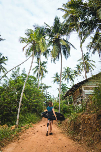 istock Female surfer carries longboard 1067444042