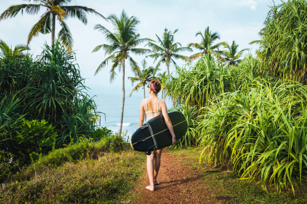 istock Female surfer carries longboard 1067444114