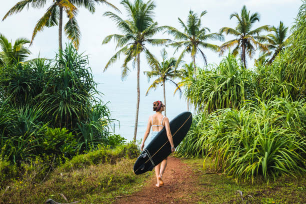 istock Female surfer carries longboard 1067444122