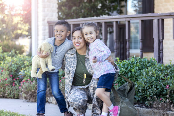 Portrait of army mom with her children Smiling mid adult army mom is happy to be reunited with her young son and daughter after overseas deployment. They are looking at the camera. proud army mom stock pictures, royalty-free photos & images