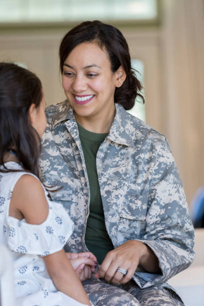 istock Smiling female soldier talks with young daughter 1067448882
