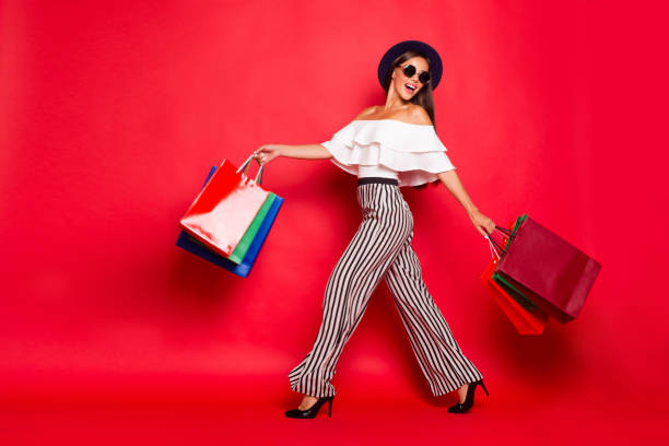 Full length body size portrait of careless carefree trendy stylish elegant chic lady wearing eyeglasses eyewear off-the-shoulders blouse top high heels shoes isolated on red background Full length body size portrait of careless carefree trendy stylish elegant chic lady wearing eyeglasses eyewear off-the-shoulders blouse top high heels shoes isolated on red background shopaholic stock pictures, royalty-free photos & images