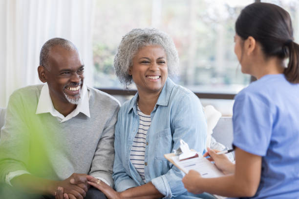 istock Senior couple laugh with doctor during home visit 1067448970