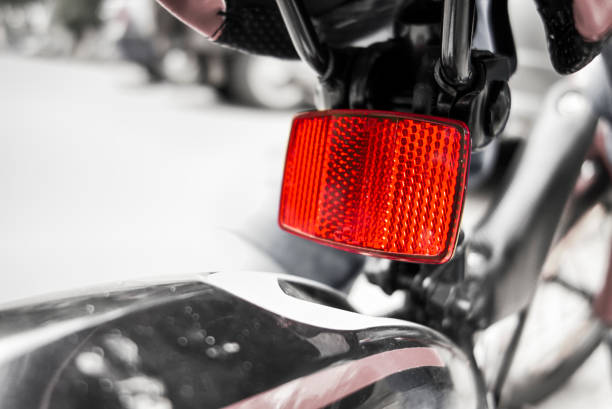 A sleek motorcycle top box with a vibrant red reflective tail light for night safety