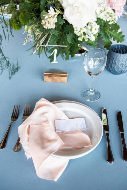 istock A plate decorated with peach napkin on sky blue tablecloth, fork and knife beside it 1067449880