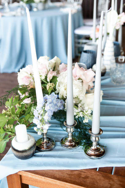istock Decorated area with flowers and candles on a silver candlestick on blue tablecloth 1067449894