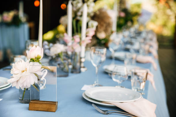 istock Long festive table with blue tablecloth decorated with flowers and candles 1067449904