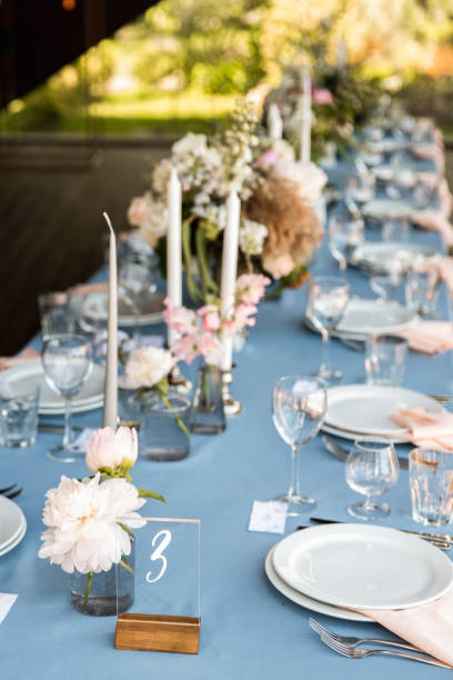 istock Festive table decorated with flowers and candles on a silver candlestick on blue tablecloth 1067449906