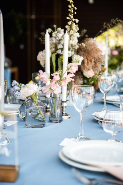 istock Long festive table with blue tablecloth decorated with flowers and candles 1067449908