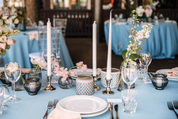 istock Festive table decorated with flowers and candles on a silver candlestick on blue tablecloth 1067450026