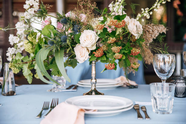 istock Festive table with blue tablecloth decorated with flowers in hight silver vase 1067450046