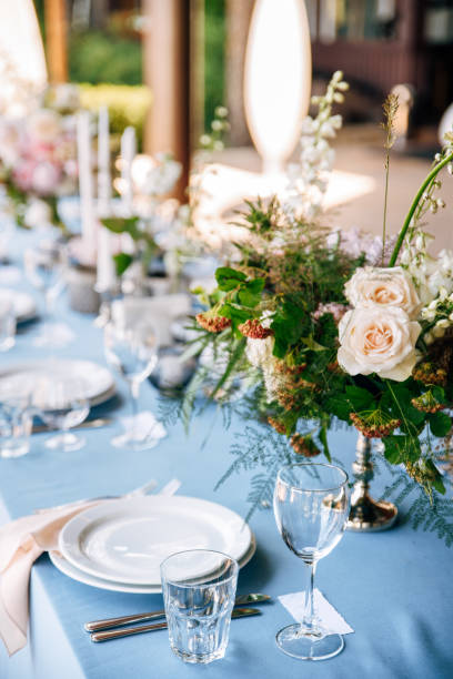 istock Festive table decorated with flowers and candles on a silver candlestick on blue tablecloth 1067450048