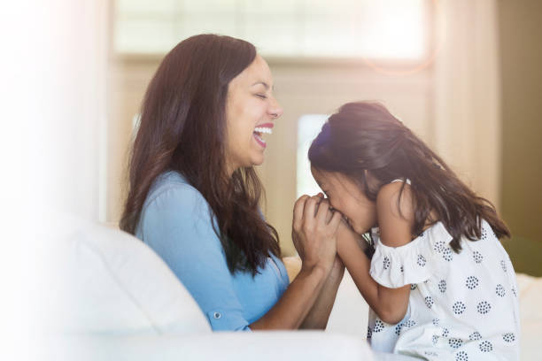 istock Mom and young daughter laughing together 1067451668