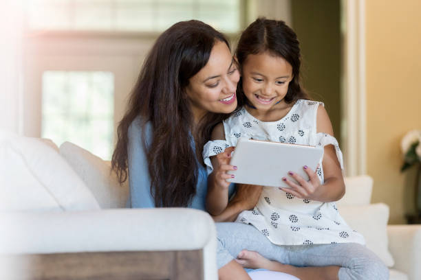 istock Mom and daughter look at digital tablet 1067451672