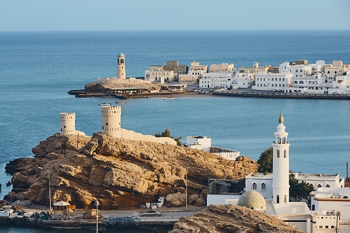 Lighthouse, watchtowers and white houses of traditional architecture of old town Sur in Sultanate of Oman.