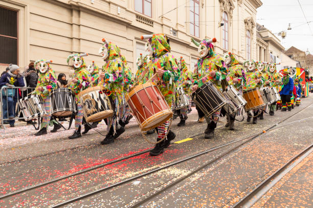 Basel carnival 2018 in Switzerland Steinenberg, Basel, Switzerland - February 19th, 2018. A group of carnival participants in colorful costumes playing snare drums fastnacht stock pictures, royalty-free photos & images