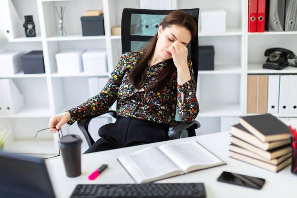 istock A young girl sitting in the office at the computer table. 1067467692