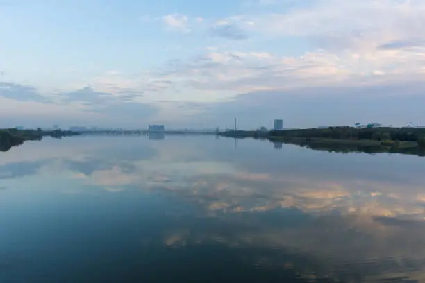 An evening look across the lake in the central China city of Wuhan boasts an unusual pollution free day with puffy clouds and a gorgeous reflection over the still waters.
