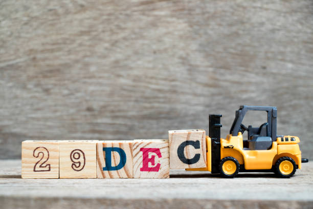 istock Toy forklift hold block c to complete word 29dec on wood background (Concept for calendar date 29 in month December) 1067476184