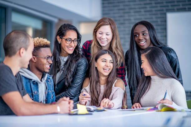 istock Group of university students studying and laughing together 1067477990