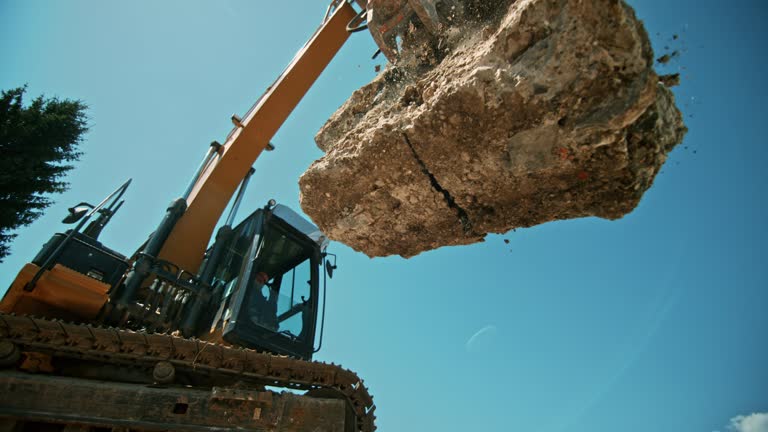 SLO MO Construction debris being released from the excavator and falling on a pile in sunshine