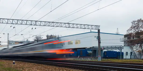 High-speed train passes the station as a symbol of the departing train. Picture taken on a long exposure and the cars blurred.