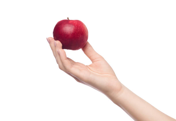 Woman's hand holding red apple, isolated on white background