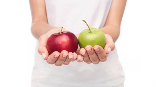 istock Woman offering two apples in her hands 1067483434