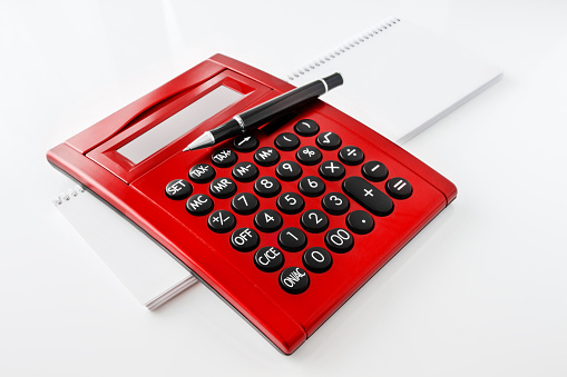 Finances  red calculator against white background