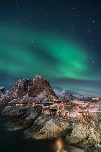 Photo of Fisherman village with Aurora in the background travel concept world explore northern light / Lofoten Norway