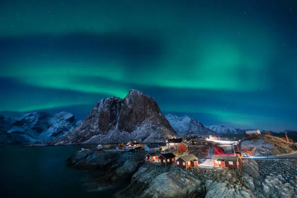 Photo of Fisherman village with Aurora in the background travel concept world explore northern light / Lofoten Norway