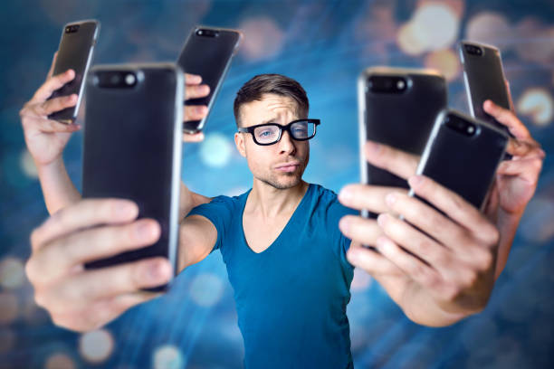 Influencer holding an exaggerated number of smartphones Young man with 6 arms is holding 6 smartphones to take a selfie. Abstract digital background with bokeh. puckering stock pictures, royalty-free photos & images