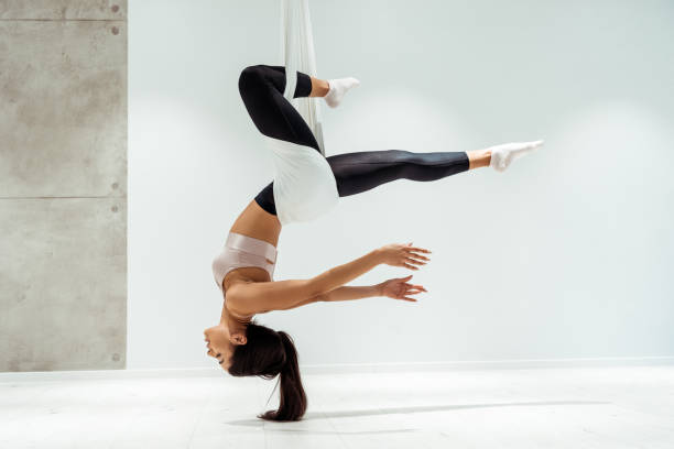 istock Beautiful relaxed girl practicing antigravity yoga in inversion position in studio 1067497586