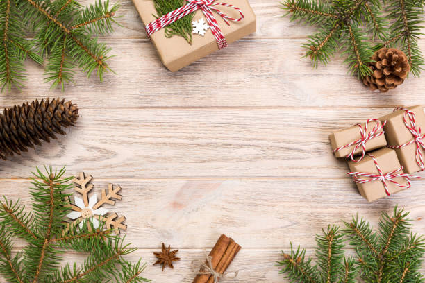 istock Christmas background with fir tree and gift box on wooden table. Top view with copy space for your design 1067502064