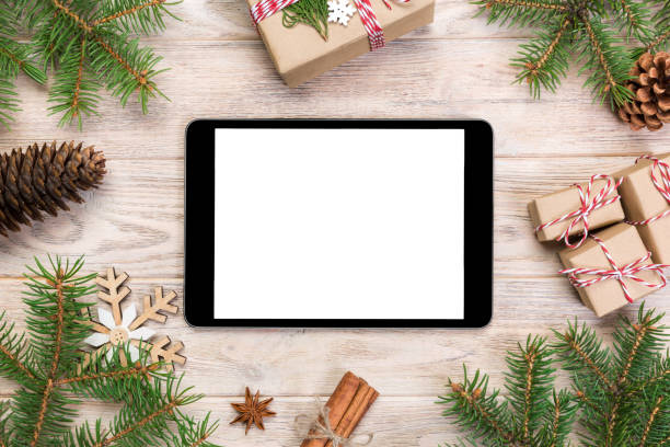 istock Digital tablet mock up with rustic Christmas wood background decorations for app presentation. top view with copy space 1067502068