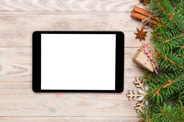 istock Digital tablet mock up with rustic Christmas wood background decorations for app presentation. top view with copy space 1067502226