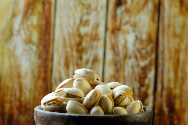 istock Bowl with pistachio on wooden table 1067505548