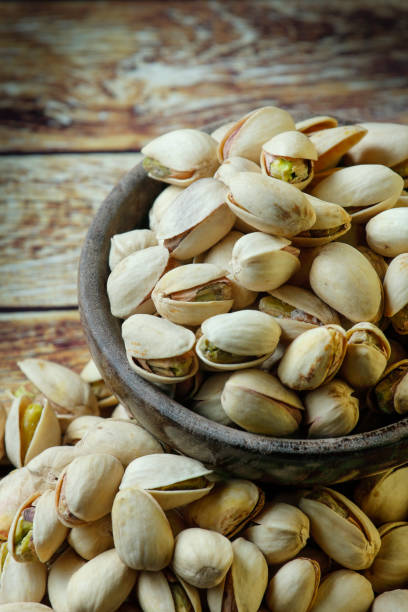 istock Bowl with pistachio on wooden table 1067505958