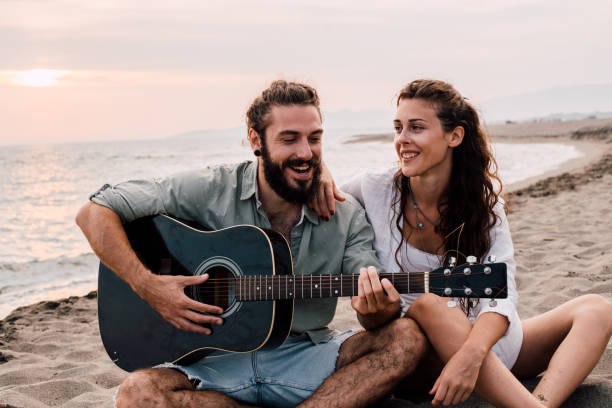 istock Happy couple with guitar at the beach 1067505990