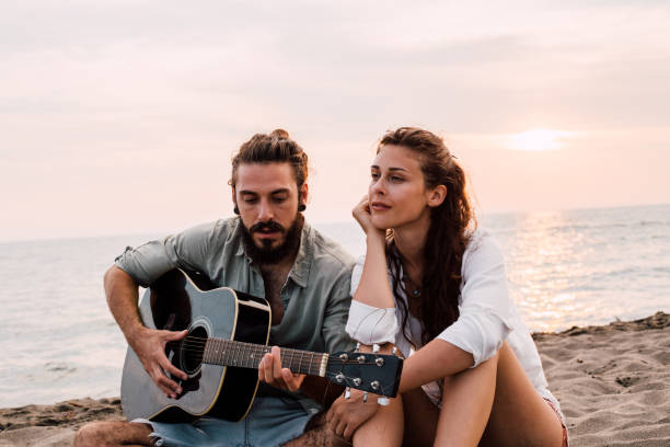 istock Couple with guitar at the beach 1067506038