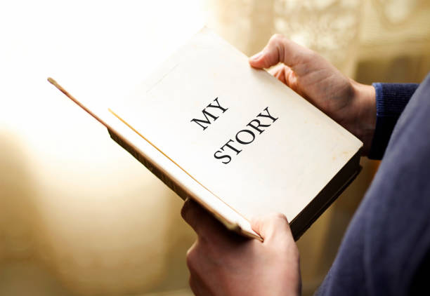 istock man holding book with title, my story 1067514546