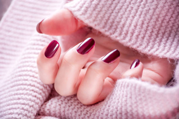 Red wine color manicure on girl hand stock photo